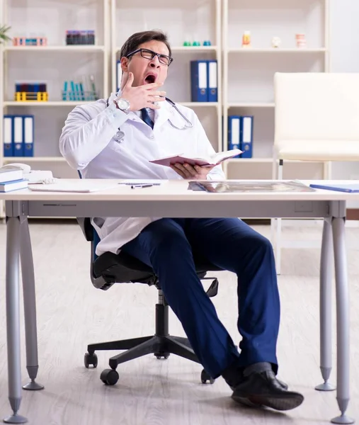 Junger Arzt sitzt im Büro — Stockfoto