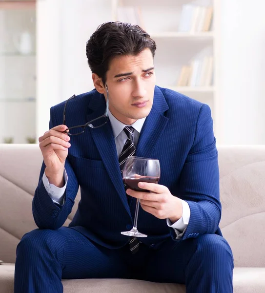 Businessman drinking wine sitting at home — Stock Photo, Image