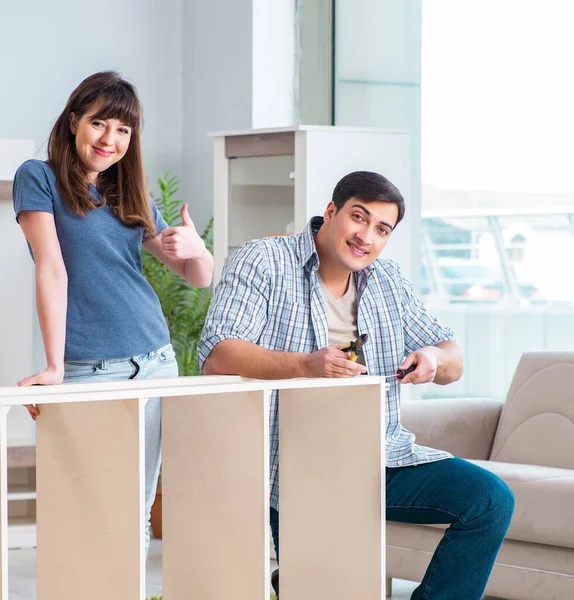 Young family assembling furniture at new house — Stock Photo, Image