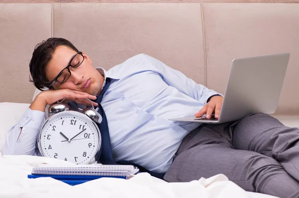 Geschäftsmann arbeitet zu Hause im Bett — Stockfoto