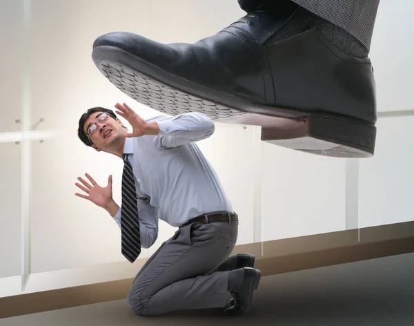 Bad angry boss stamping on employee in business concept Stock Photo