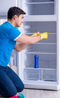 Hijyen konseptinde buzdolabını temizleyen adam.