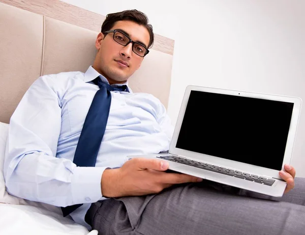 Geschäftsmann arbeitet zu Hause im Bett — Stockfoto