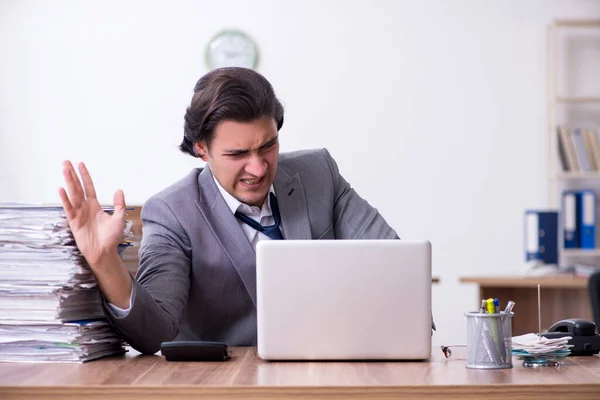 Giovane dipendente maschio infelice con il lavoro eccessivo — Foto Stock