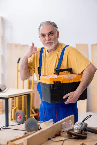 Oude mannelijke timmerman aan het werk in werkplaats — Stockfoto