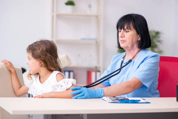 Petite fille visitant un vieux médecin féminin — Photo