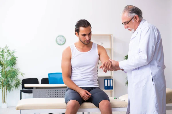 Paciente masculino joven que visita al médico experimentado — Foto de Stock