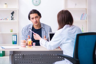 Genç adam kadın doktor stomatoloğu ziyaret ediyor.