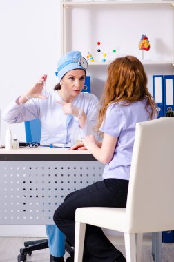 Kadın doktor otolaringolojisti ziyaret eden genç bir kadın.
