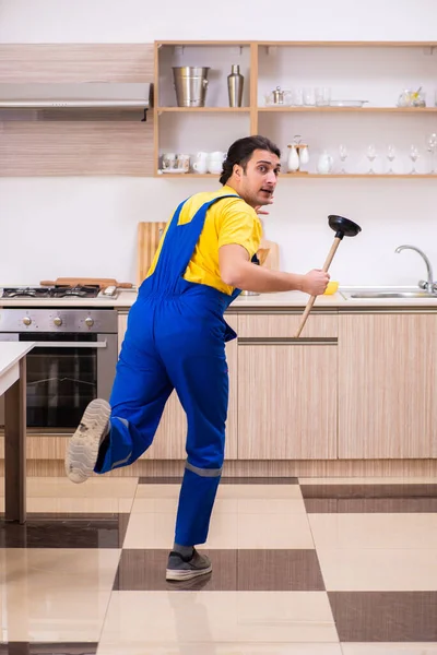 Jovem empreiteiro masculino reparando torneira em casa — Fotografia de Stock