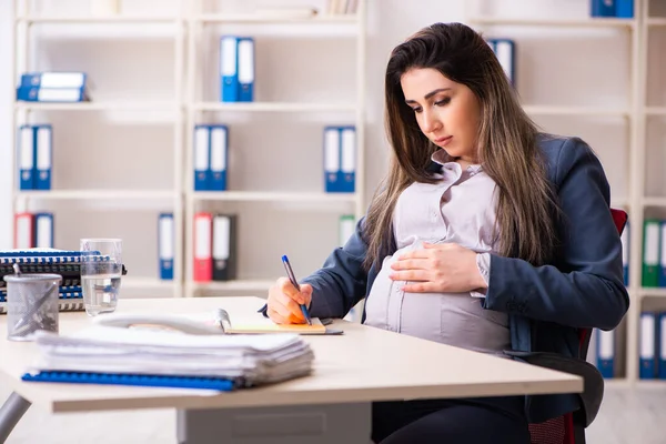 Jeune femme enceinte travaillant dans le bureau — Photo