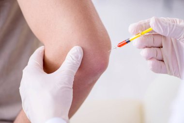 Erkek hasta aşı aşısı için doktoru ziyaret ediyor.