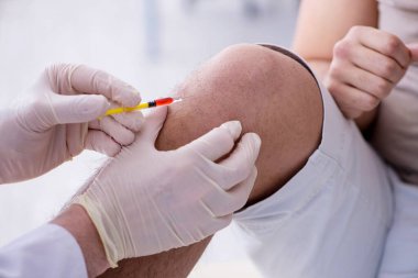 Erkek hasta aşı aşısı için doktoru ziyaret ediyor.