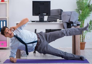 İş adamı tatilde ofiste spor yapıyor.