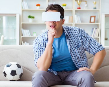 Sanal gerçeklik gözlüğü takan bir adam futbol maçı izliyor.