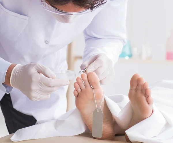 Police coroner examining dead body corpse in morgue — Stock Photo, Image