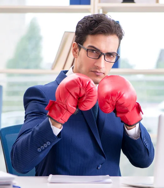Бизнесмен в боксёрских перчатках злится в офисе — стоковое фото