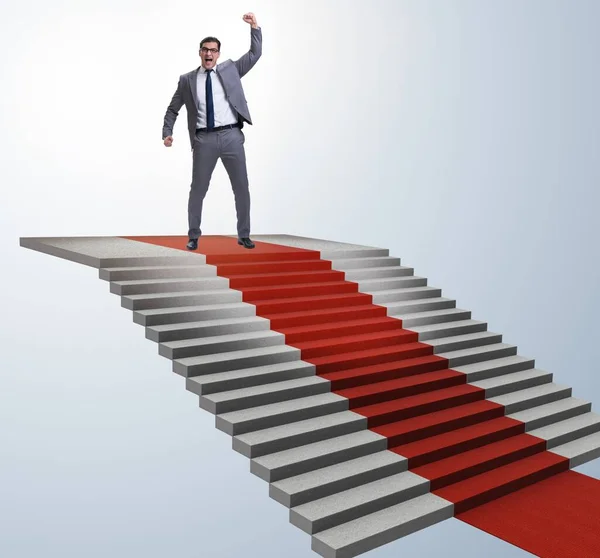 Молодий бізнесмен скелелазіння сходів і червоний килим — стокове фото