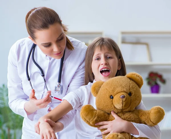 Žena žena lékař zkoumání malé roztomilé dívka s hračkou medvěd — Stock fotografie