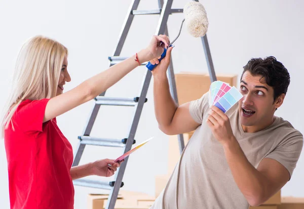Família jovem fazendo trabalho de pintura durante a renovação da casa — Fotografia de Stock