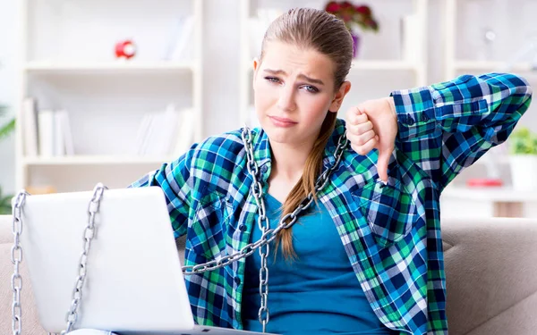 Chained female student with laptop sitting on the sofa — Stock Photo, Image