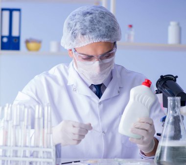 Laboratuvardaki adam yeni temizlik çözeltisi deterjanı test ediyor.