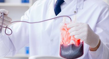 Hastane kliniğinde kan örnekleriyle çalışan bir doktor.