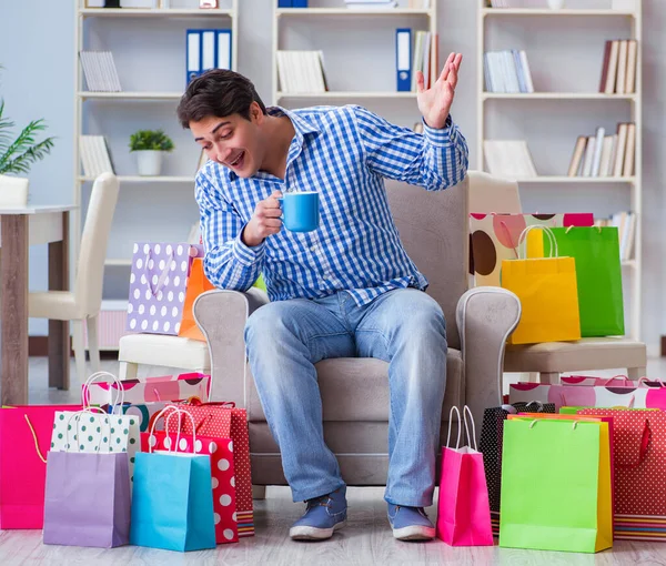 Ung man efter överdriven shopping hemma — Stockfoto