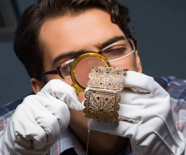 Jonge mannelijke juwelier die 's nachts in zijn atelier werkt — Stockfoto