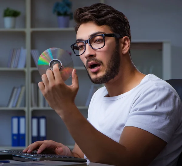 Genç adam fazla mesai yapmak için geç saatlere kadar ofiste kalıyor. — Stok fotoğraf