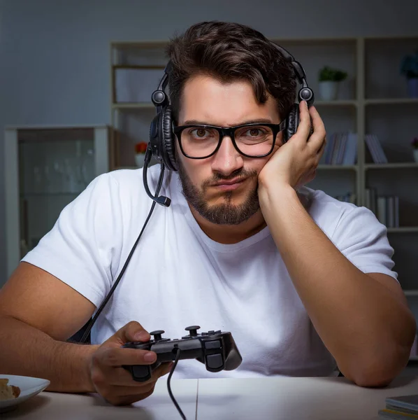 Jovem jogando jogos longas horas atrasado no escritório — Fotografia de Stock