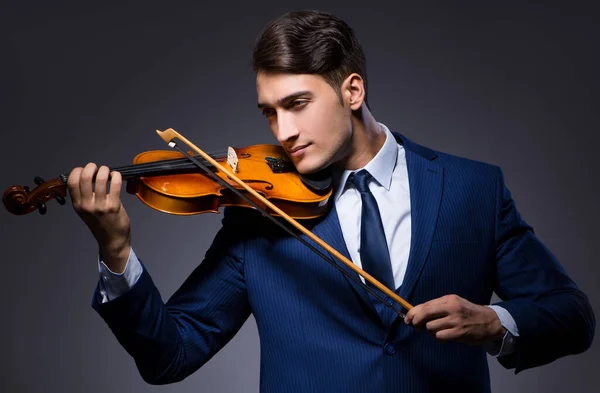 Jovem tocando violino no quarto escuro — Fotografia de Stock