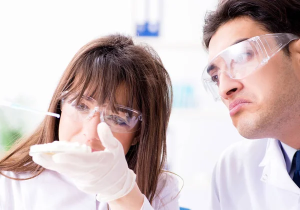 Dois médicos de laboratório testando produtos alimentares — Fotografia de Stock