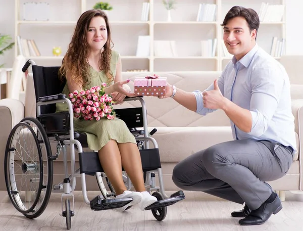 Mężczyzna oświadczający się niepełnosprawnej kobiecie na wózku inwalidzkim — Zdjęcie stockowe