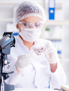 Bir laboratuarda deney yapan kadın bir bilim adamı.