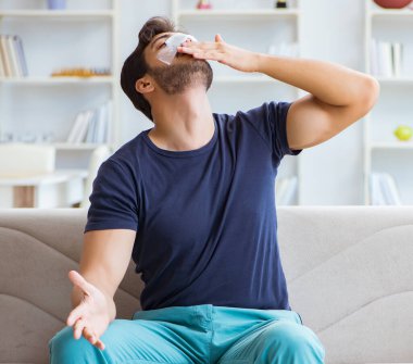 Genç adam estetik cerrahi burnundan sonra evde iyileşiyor.