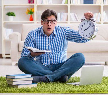 Genç yakışıklı adam evde yerde oturuyor.