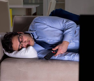 İşadamı gece geç saatte televizyon izliyor.