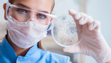 Bir laboratuarda deney yapan kadın bir bilim adamı.