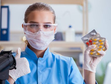 Bir laboratuarda deney yapan kadın bir bilim adamı.