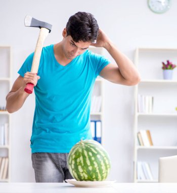 Evde karpuz yiyen bir adam.