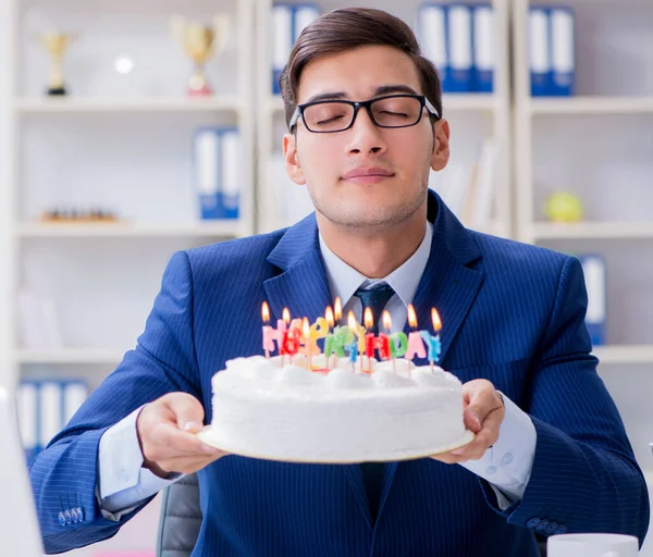Молодой бизнесмен празднует день рождения в одиночестве в офисе — стоковое фото