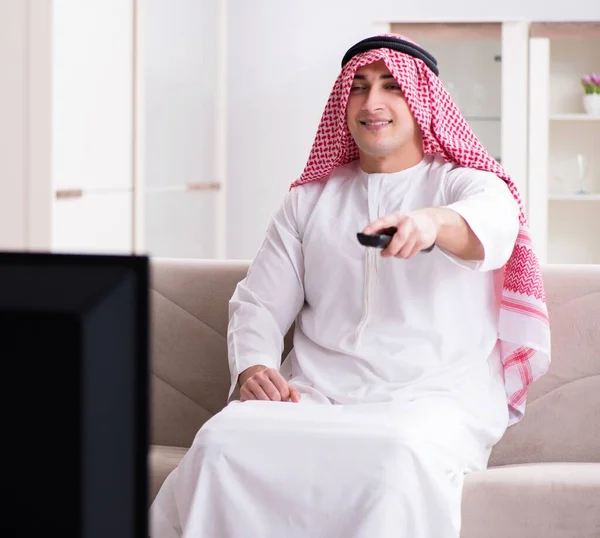 Арабський чоловік дивиться телевізор удома. — стокове фото