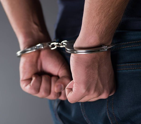 Man with his hands handcuffed in criminal concept
