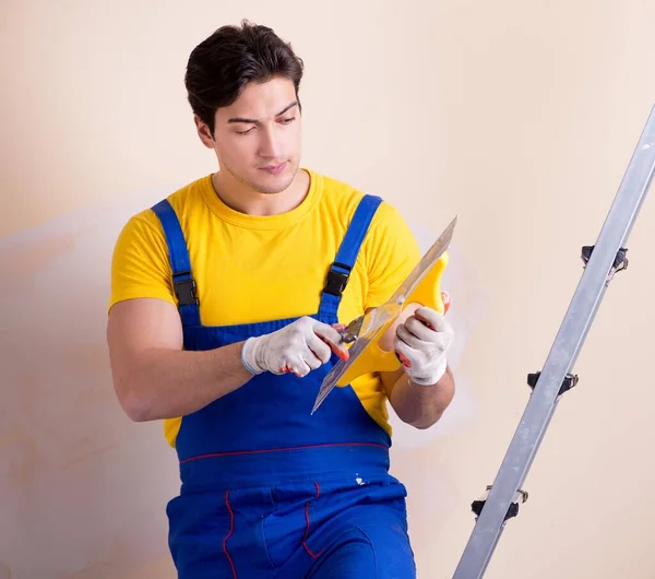 Young contractor employee applying plaster on wall — Stock Photo, Image