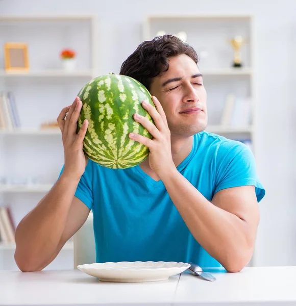 Man die thuis watermeloen eet — Stockfoto