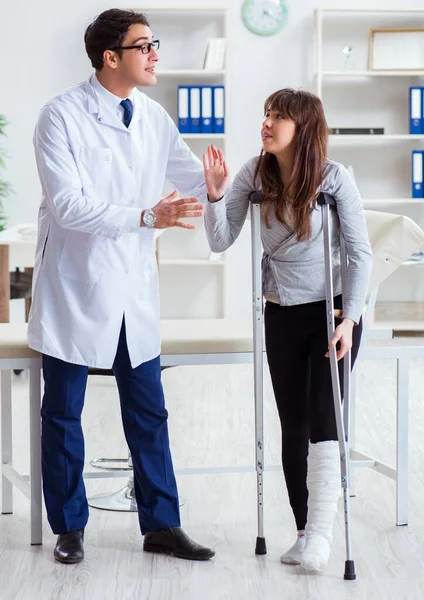 Médico examinando paciente com perna quebrada — Fotografia de Stock