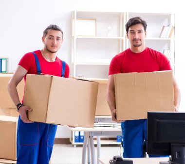 İki müteahhit personel kişisel eşyalarını taşıyor.