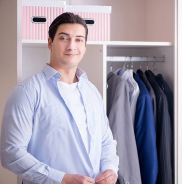 Genç işadamı iş için giyiniyor.