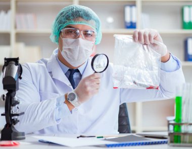 Adli tıp dedektifi suç delili üzerinde çalışıyor.